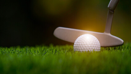 Golf clubs and balls on a green lawn in a beautiful golf course with morning sunshine.