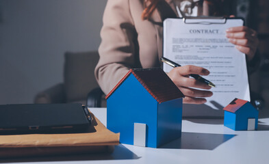 Female Real Estate Broker presenting and advised to .model home and building project detail in the...