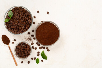 Obraz premium Roasted coffee beans with leaves on concrete background,top view