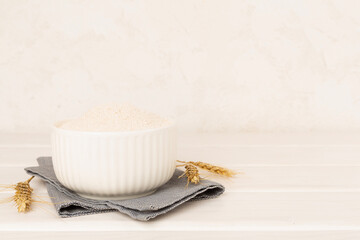 Bowl with spelt flour on wooden table