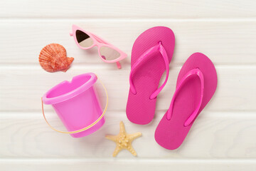 Children's flip flops and beach toys on wooden background,,top view