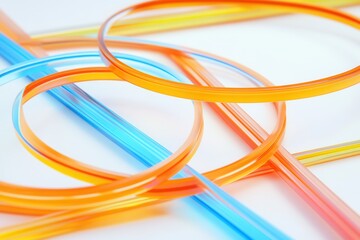 Colorful plastic straws in vibrant orange and blue arranged artistically on a white background