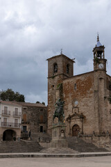Equestrian statue dominating square in front of church in pals, spain