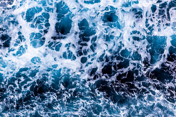 Ocean water surface background. Aerial view of vibrant foamy water. Can be used in covers, packaging, posters, textures, brochures, art and design projects. Mesmerizing nature background image.
