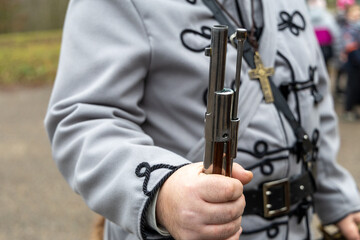 Historical reenactor holding a musket in traditional military uniform
