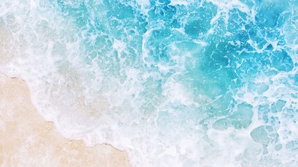 Top view of ocean foam splashing on white sandy coastline in bright daylight.