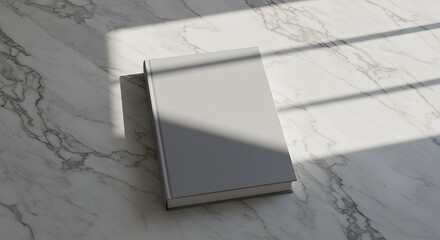Grey Hardcover Book on Marble Surface with Sunlight Shadow