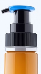 Fototapeta premium Dispenser top, clear orange bottle, black nozzle, blue cap, and shiny silver base