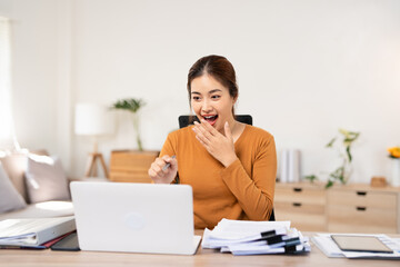 Obraz premium Startup small business entrepreneur SME of freelance Asian woman using a laptop in home office. Cheerful success Asian woman surprise celebrate for online marketing. SME idea concept.