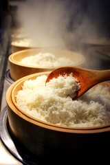 Freshly cooked, fluffy white rice being served from bamboo bowls with a wooden spoon.