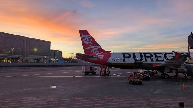 Air Asia airline airplane on runway with beautiful sunset sky at Ninoy Aquino International Airport in Manila Philippines - taken on 29th April 2025