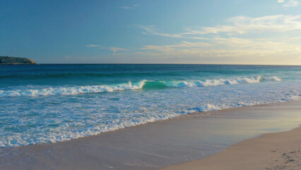 Fototapeta premium A person walking on a beach carrying a surfboard, great for outdoor and sports-themed projects