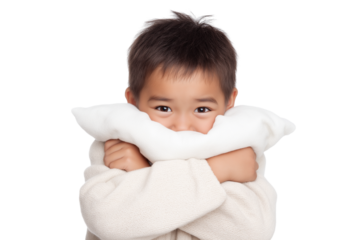 young boy hides his face behind white pillow isolated on white transparent background