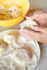 Caucasian hands making cottage cheese pancakes with raisins