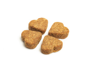 Isolated treat in heart-shaped for cats or dogs. Group of brown soft chews for pets. Cookies or snacks to supplement diet with vitamins or medication. Selective focus. White background.