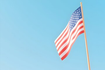 An American flag gently waving against a clear blue sky