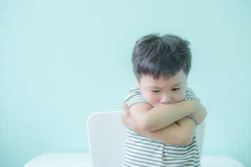 Lonely boy sitting alone. Preschool child with unhappy or sad face. Copy space for text.