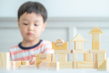 Portrait of kid cute asian boy playing a blocks wood game. selective focus. Copy space. Executive Functions Concept.