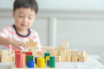 Portrait of kid cute asian boy playing a blocks wood game. selective focus. Copy space. Executive Functions Concept.