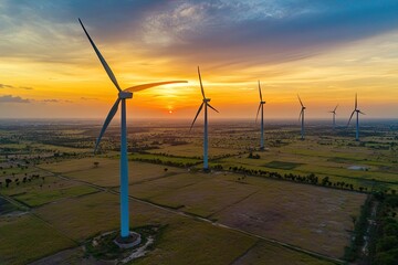 Aerial view of wind turbines at sunset over agricultural fields