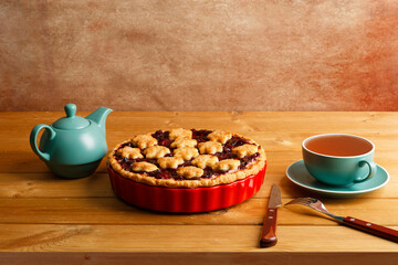 Homemade berry pie cup of tea on wooden table. Copyspace.