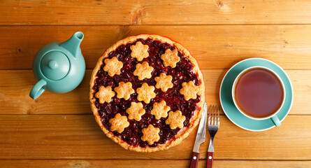 Homemade berry pie cup of tea on wooden table. Top view.