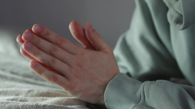 Close-up of a man stroking his hands against each other, mulling something over