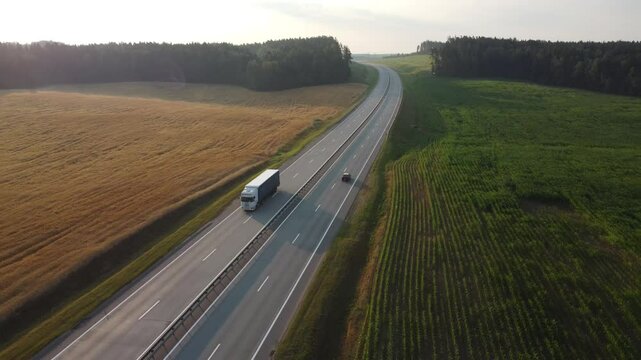 Aerial view of a cargo truck driving on a rural highway, highlighting ground transportation, freight delivery, and logistics infrastructure in a calm and efficient road network setting. 4k footage