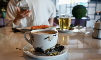 Cup of cappuccino coffee for breakfast in cafeteria. lifestyle photo