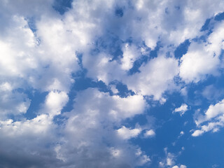 Obraz premium Aerial view of a serene cloudscape with soft, fluffy white clouds floating under a clear blue sky — peaceful and natural beauty above the earth.