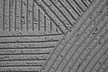 gray background, photo shows texture of decorative plaster on concrete wall close-up