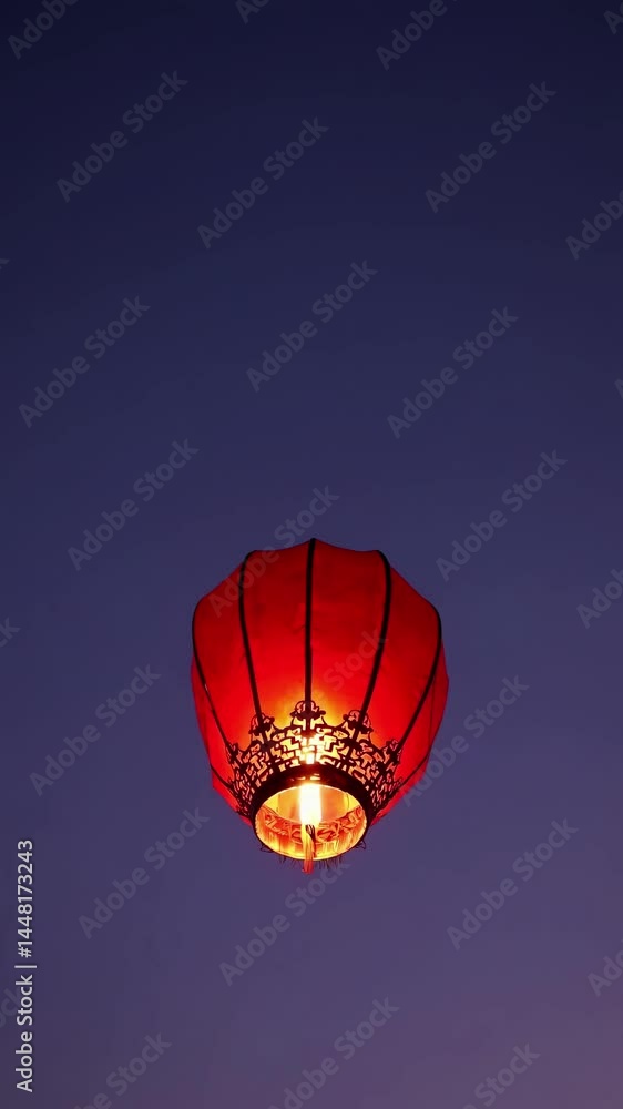 Poster aerial view of a glowing red lantern against a twilight sky, creating a serene and mystical atmosphe