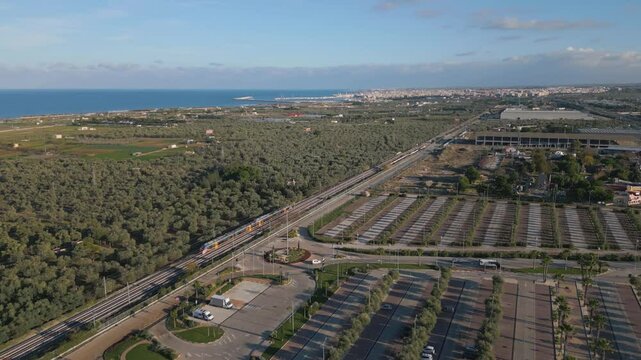 Aerial drone video of a train riding on the railway tracks in Molfetta, Italy