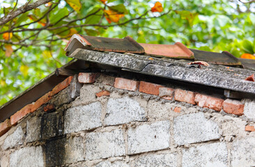 A roof with a brick wall and a tree in the background