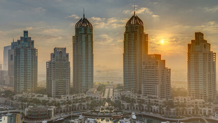 Naklejka premium View of modern skyscrapers shining in sunrise lights timelapse in Dubai Marina in Dubai, UAE.