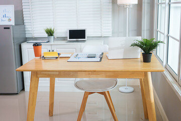 A casually dressed Asian businesswoman works from home while meeting online with a client, looking relaxed, focused and professional despite the informal setting.