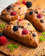 Triangular English scones with blackberries, raspberries and chocolate chips.