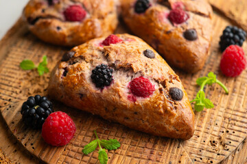 Triangular English scones with blackberries, raspberries and chocolate chips.