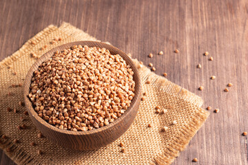 Buckwheat groats on wooden background. Healthy cereal concept.  