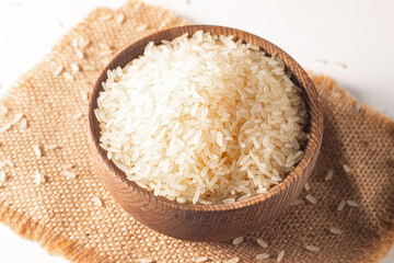 Uncooked white rice in a wooden bowl. Healthy cereal concept