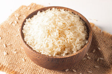 Uncooked white rice in a wooden bowl. Healthy cereal concept