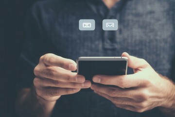 Man holding smartphone with messaging icons, focused on communication in dark setting