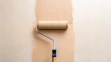 Obraz premium Beige paint roller applying fresh paint on wall, showing smooth texture and even coverage in home renovation project. roller is partially covered with paint