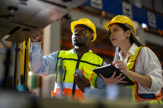 Technician industrial worker inspecting aluminum metal sheet fabricating roll check stock materials in the steel coil storage area, rolls metal sheet high quality durable meet standards industry.