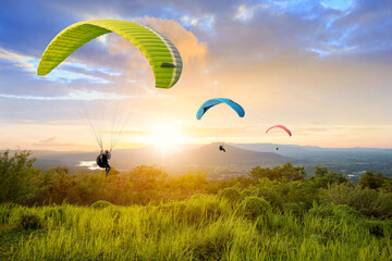 Paragliding in the sky. Paraglider flying over Landscape sun set Concept of extreme sport,.