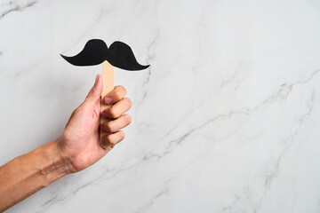 Male Hand holding mustache supporting prostate cancer awareness month and men's health