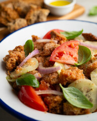 Panzanella is an Italian salad with bread, basil, bell pepper, cucumber, and tomato, popular in the Florence region.