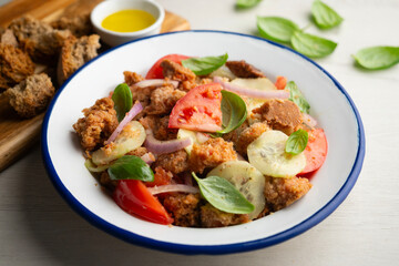 Panzanella is an Italian salad with bread, basil, bell pepper, cucumber, and tomato, popular in the Florence region.