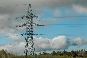 Steel lattice transmission towers supporting high voltage power lines under a bright blue sky with...