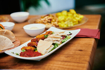 A plate of food with a variety of items including a salad, a sandwich, and a few other items